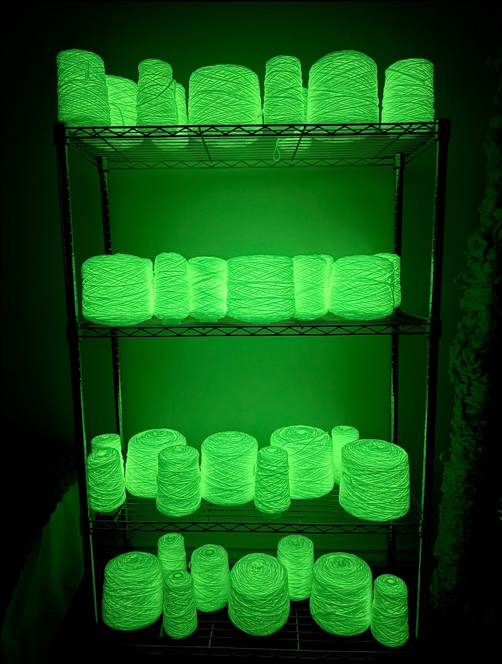 Shelf with glowing green yarn on a black background