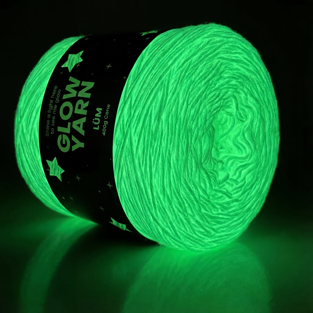 Glow-in-the-dark yarn ball with 'Löw' label on a black background