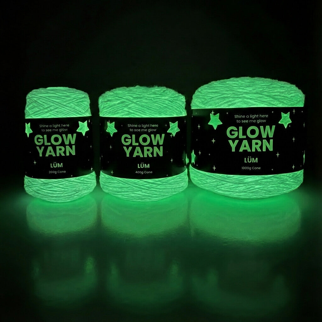 Three skeins of glow yarn with labels on a dark background